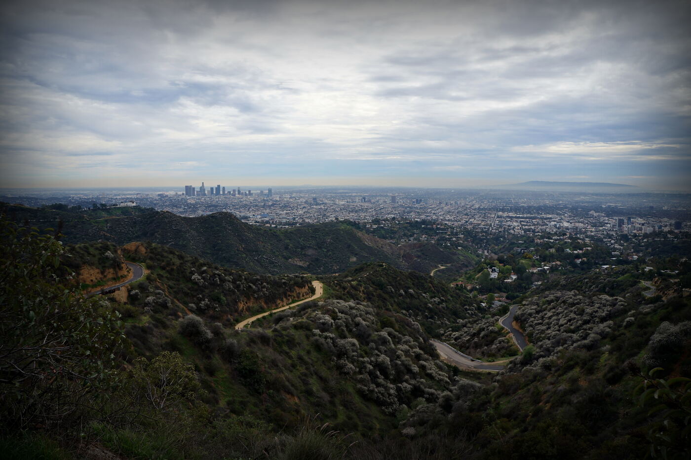 Brush Canyon Trail winding through chaparral with downtown Los Angeles beyond