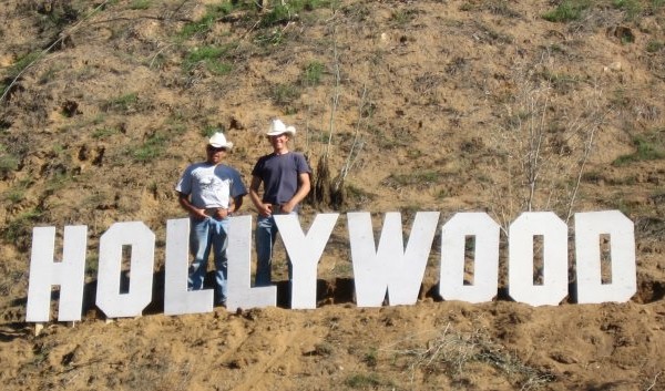 Two guys posing with the Hollywood Sign replica at Sunset Ranch